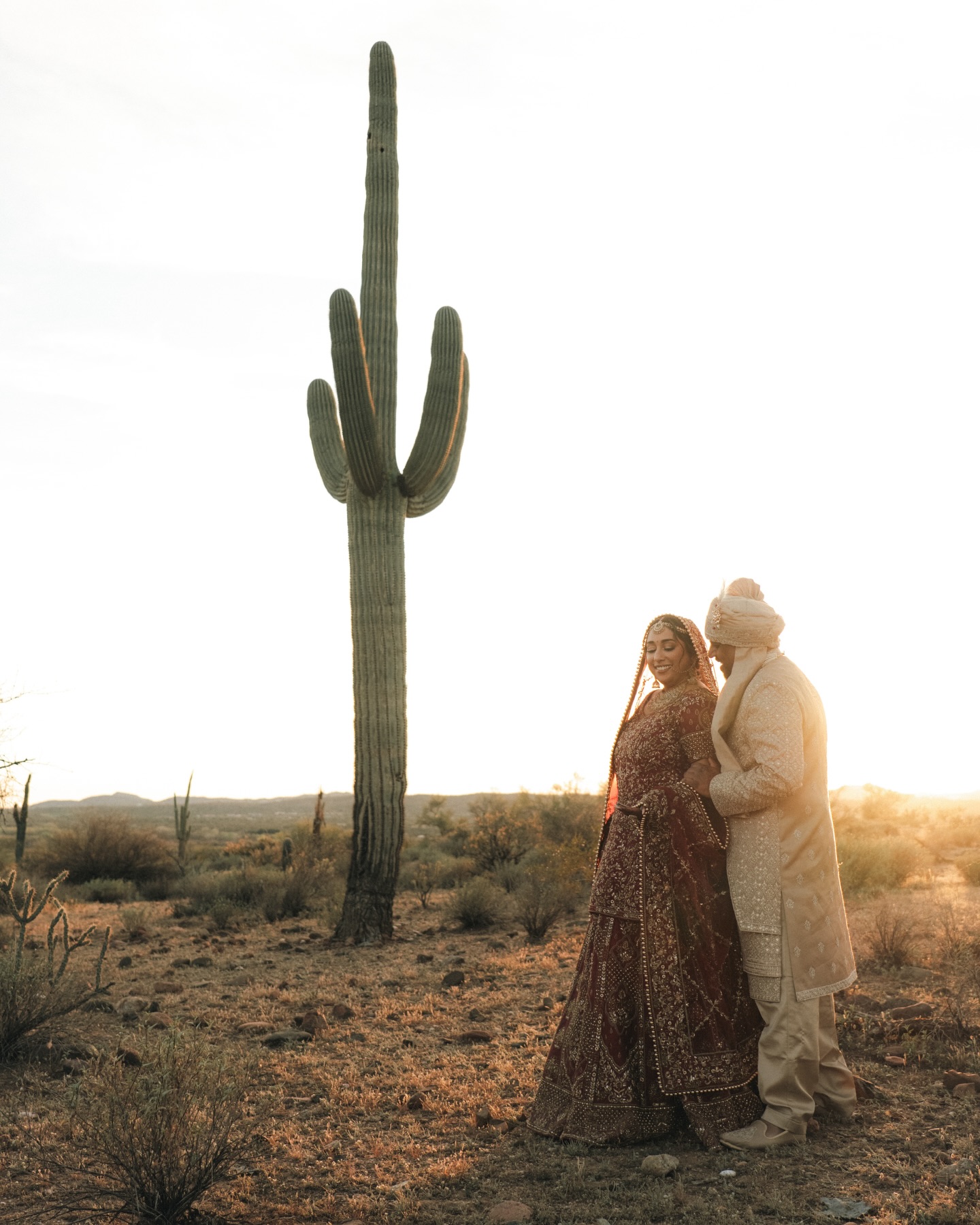 Shachi and Roni together beneath a desert arch
