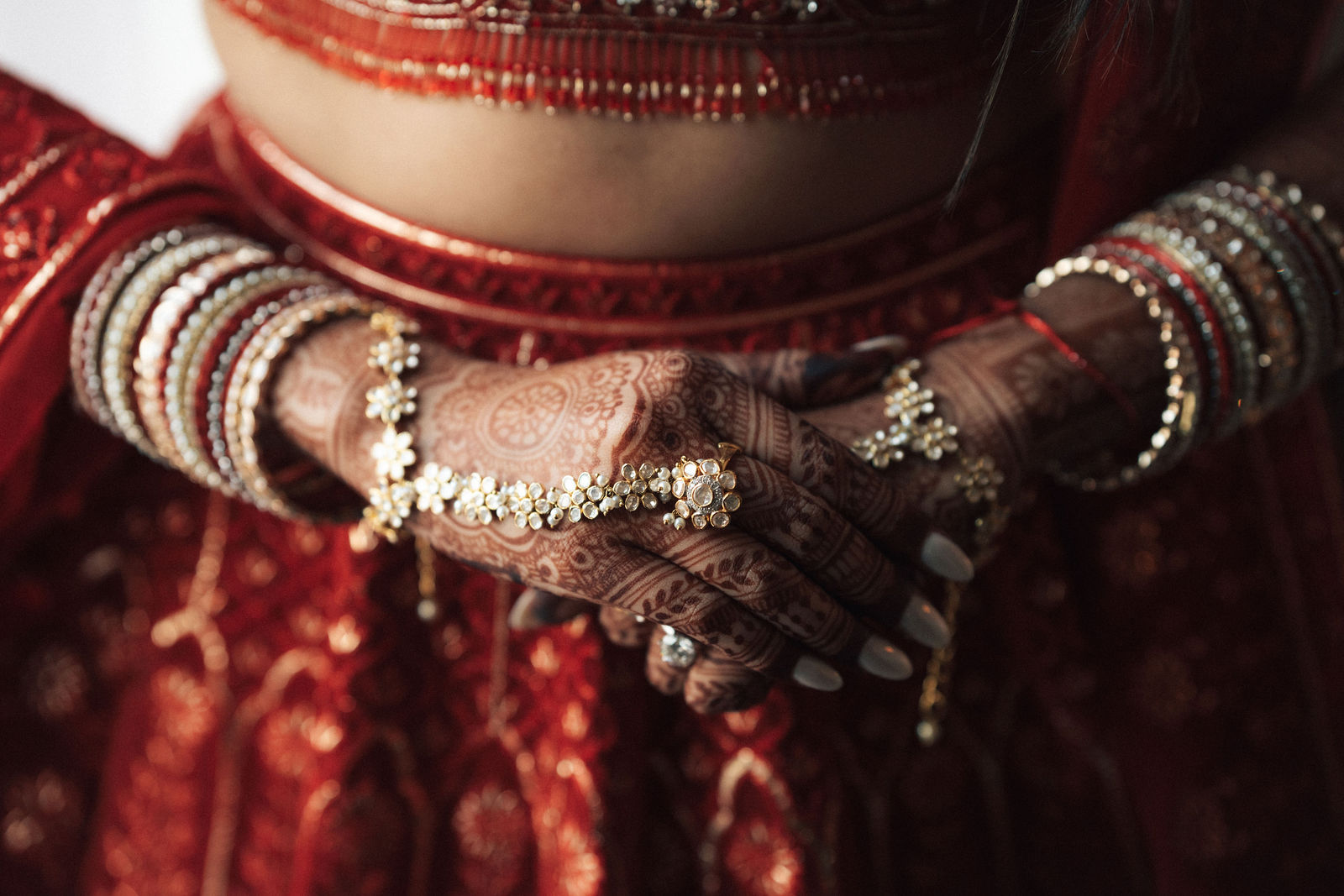 Close detail of Sonalii’s wedding jewelry and red embroidery