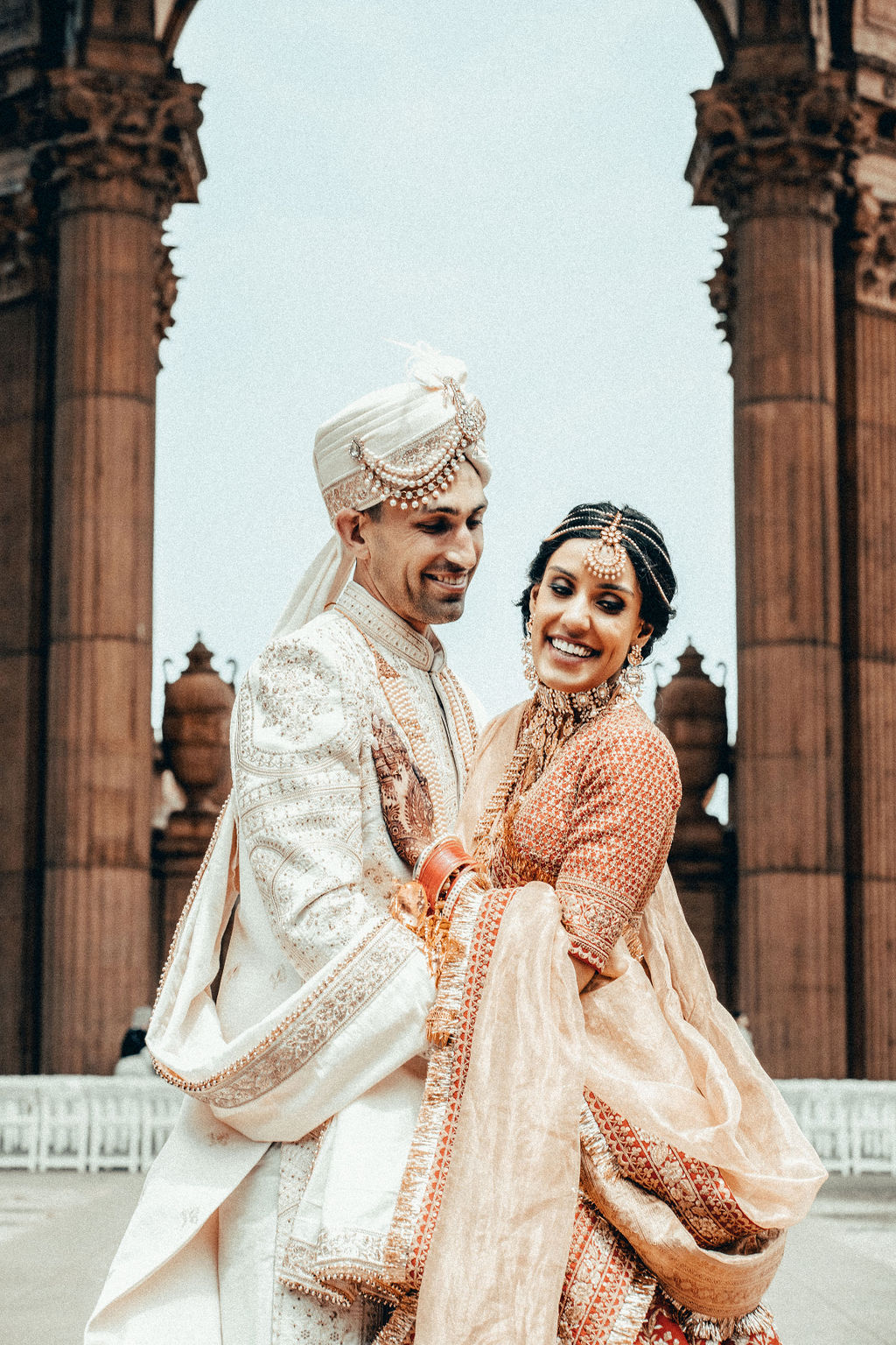 Vishalli and Lewis beneath a historic arch