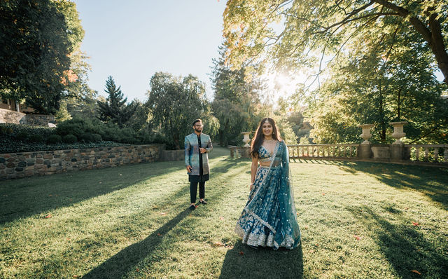 Vidhi and Mayank crossing the garden with long shadows behind them