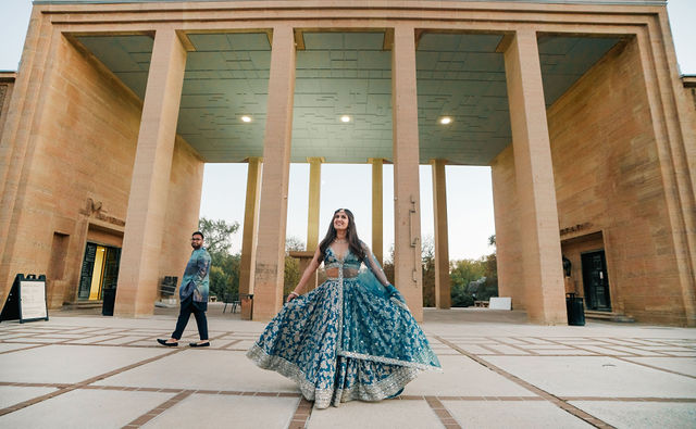 Vidhi's blue dress moving across the portico as Mayank looks on