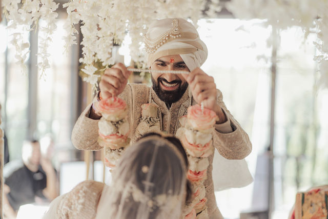 Varun smiles as he adjusts his wedding outfit