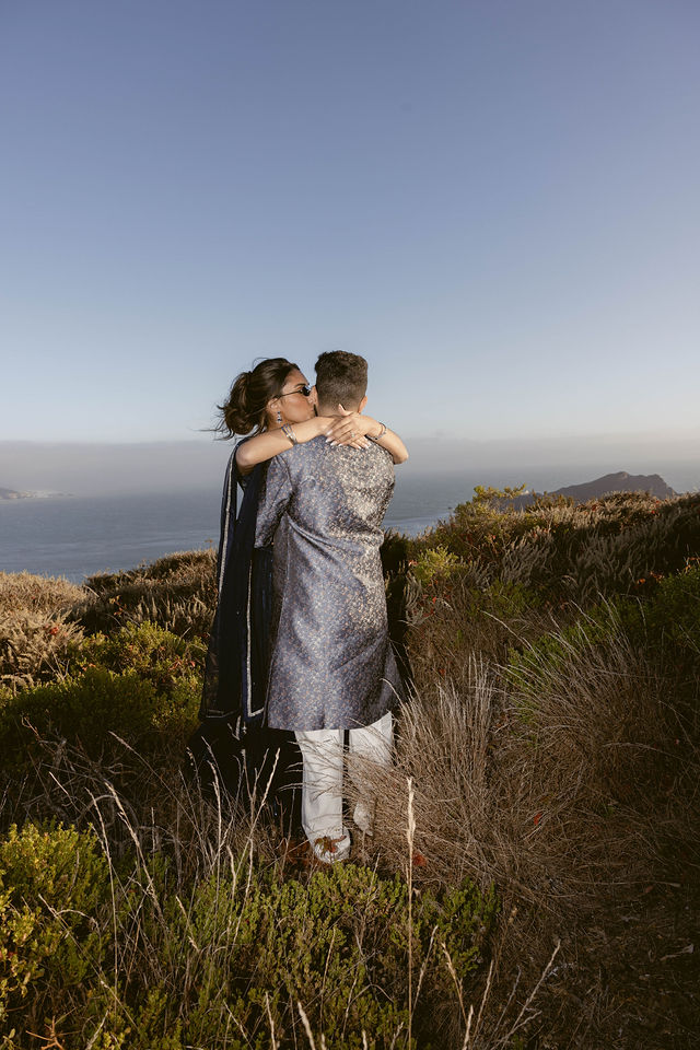 Yash and Parth embracing in the coastal grasses