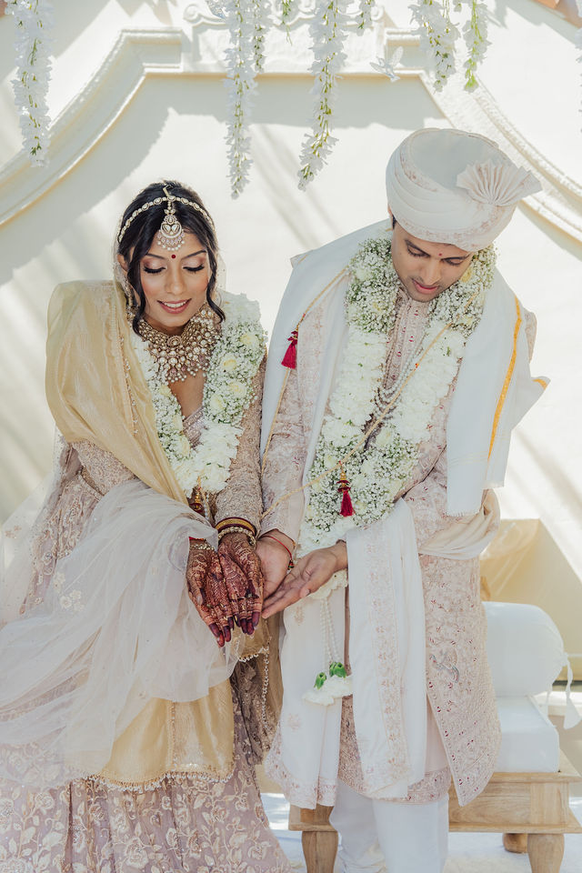 Zohal and Jairam with family beneath the white wedding canopy